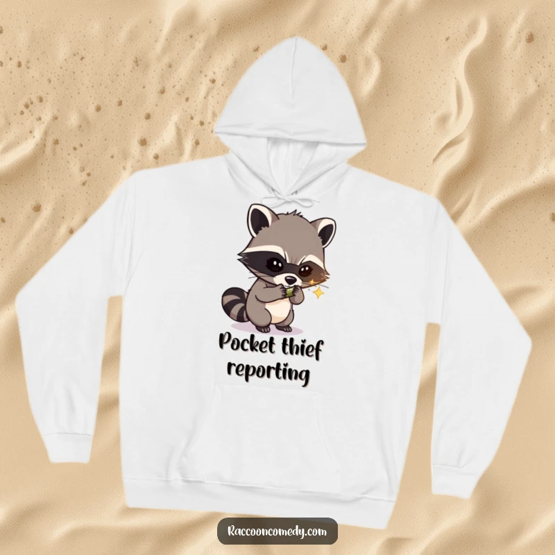Funny hoodie illustrated with a masked raccoon bandit slyly stealing a shiny object, radiating mischievous humor and warmth.