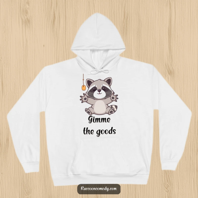 Funny raccoon hoodie featuring a cute trash panda with outstretched paws, trying to snag a prize, depicting a moment of funny determination and desire.