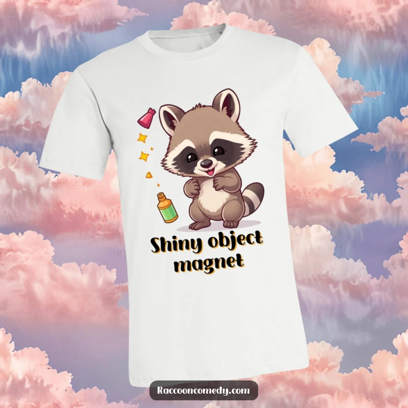 Funny t-shirt with an illustration of a happy raccoon juggling various shiny items, embodying playful mischief.