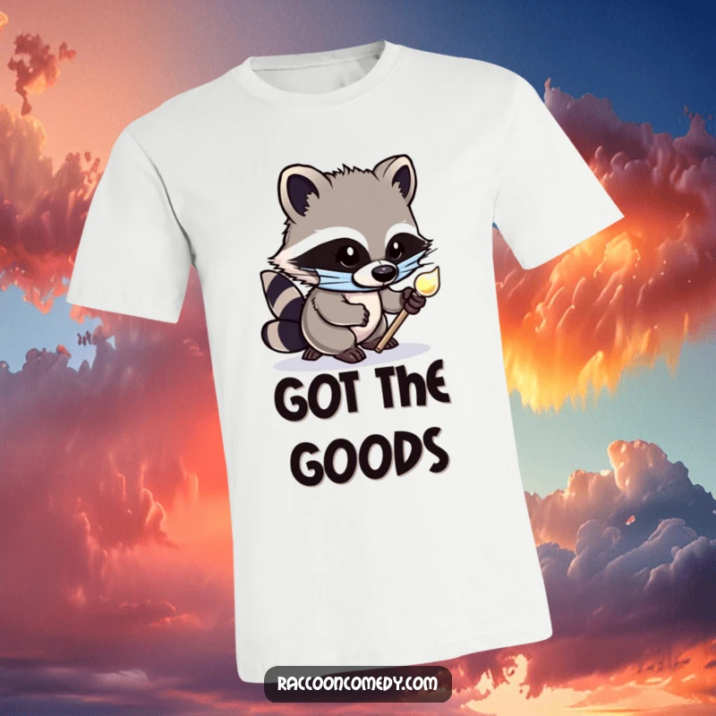 Funny T-shirt featuring a cute, masked raccoon character tiptoeing with exaggerated stealth, clutching a glittering shiny object, designed for amusement.