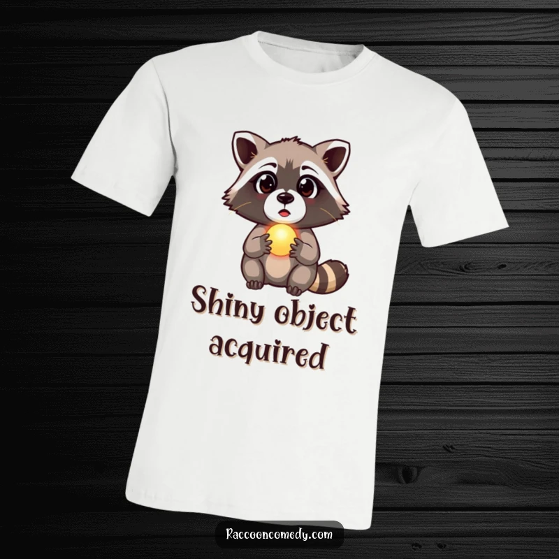 Funny raccoon t-shirt depicting a raccoon with wide, surprised eyes holding a small, luminous orb, a mystical and funny gift.