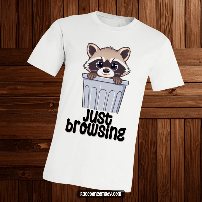 Funny t-shirt design of a raccoon with wide, curious eyes peeking out from a trash can, highlighting playful nosiness and humor.